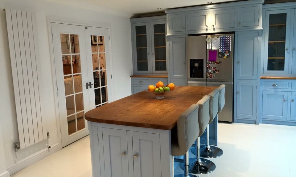 Tailor made solid wood shaker style kitchen finished in Farrow & Ball Parma Grey.Fully bespoke island site with wide plank solid oak surface top.