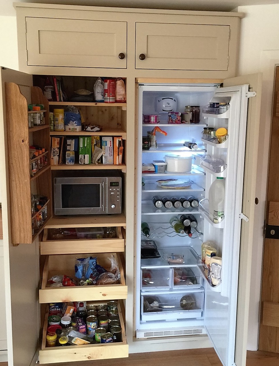 Fully bespoke housekeepers cupboard incorporating integrated fridge, hand built from solid wood.